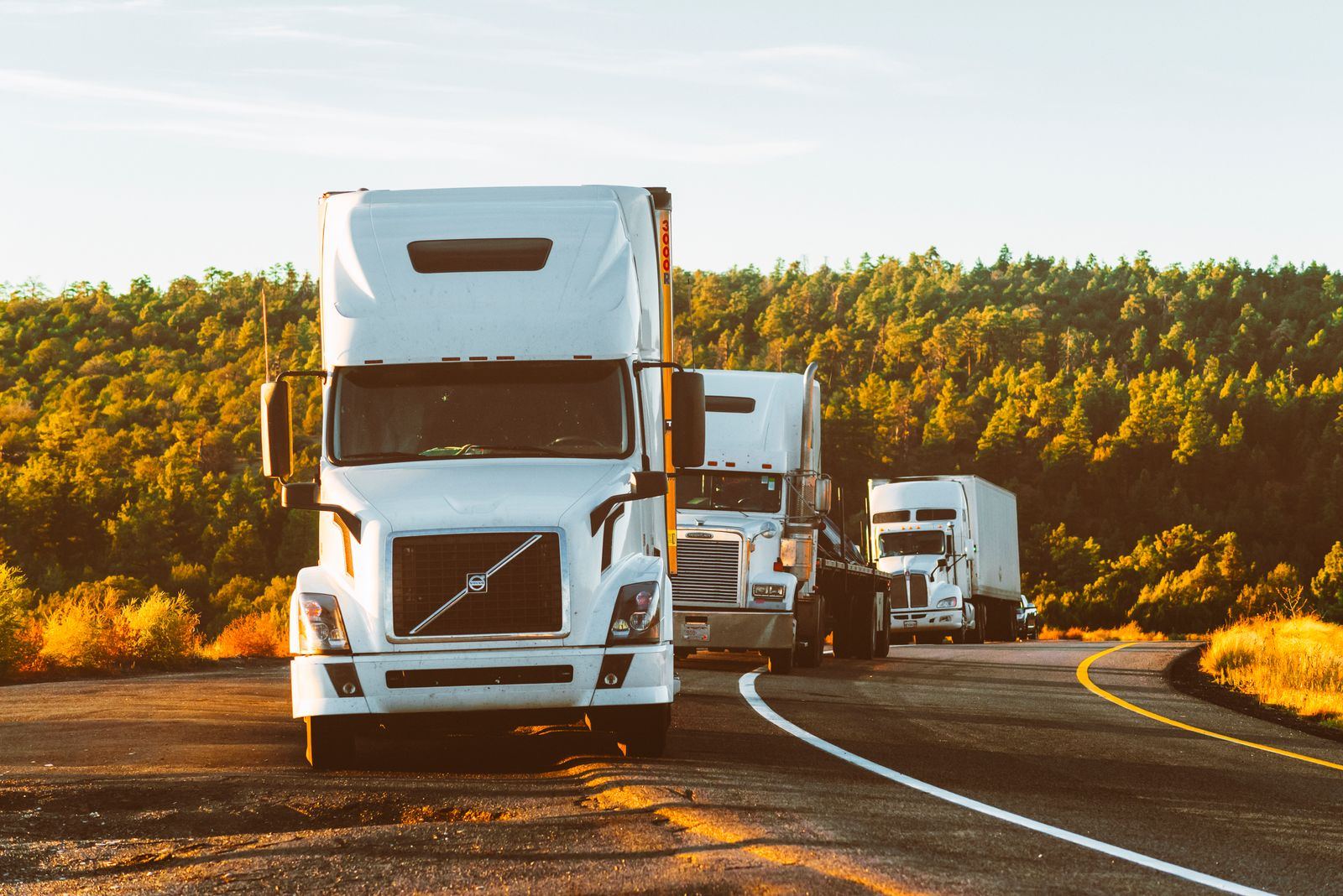 Semi truck driving into golden hour on an open highway
