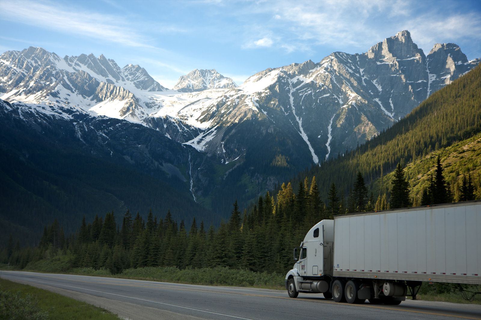 Semi truck hauling a trailer on a mountain highway